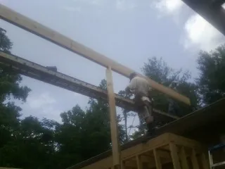 Carpenter setting a ridge beam over a new addition frame — Ice Dam Removal by Roofing Brothers in Sciota
