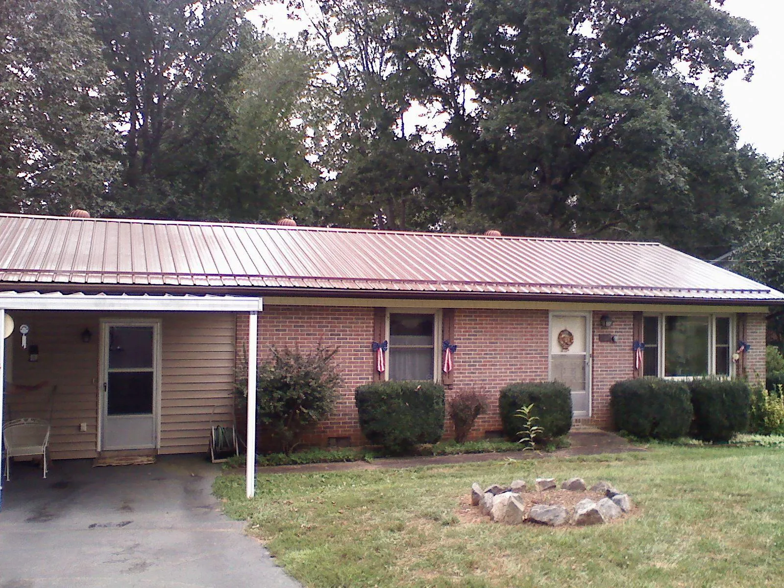 Bronze metal roof and carport on a brick ranch home — Roof Repair work by our crew in Sciota